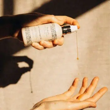 Dispensing organic cleansing oil into palm showing texture