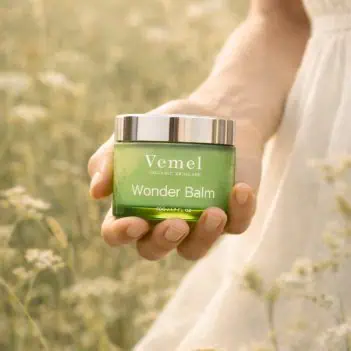 model holding organic waterless Wonder Balm skin barrier balm in nature